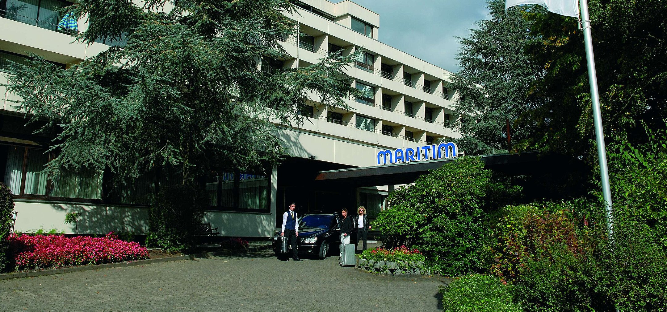 Guests arrive at Maritim Hotel Bad Salzuflen surrounded by trees and landscaped greenery