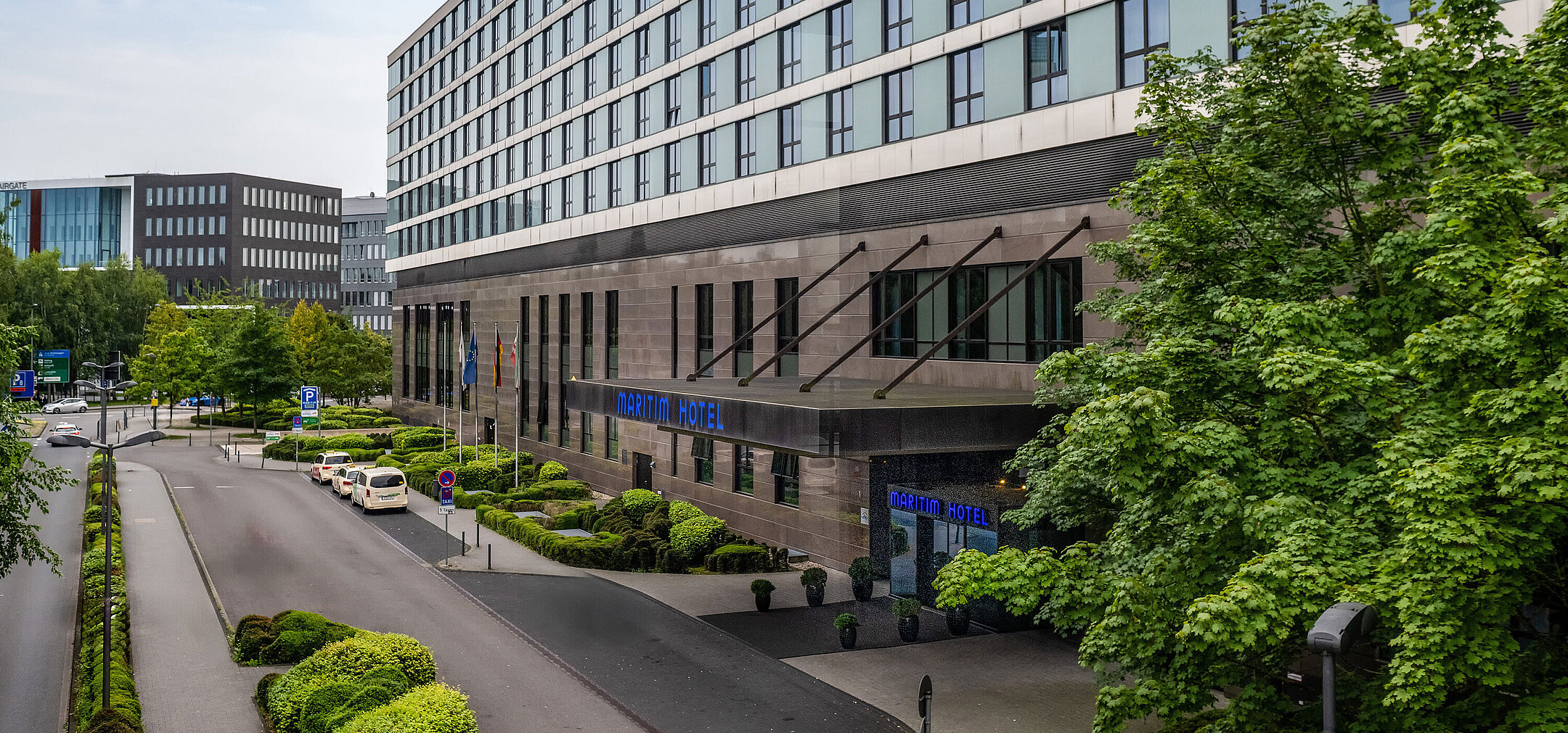 Side view of Maritim Hotel Düsseldorf with driveway and entrance